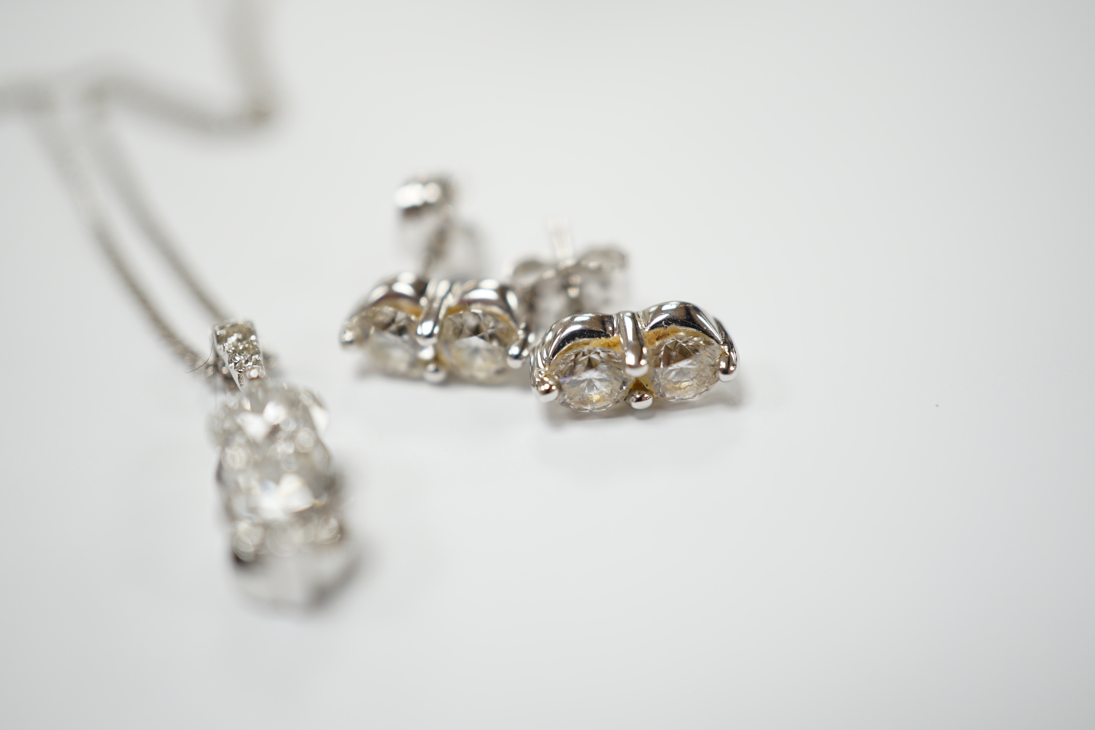 A modern 14k gold and two stone diamond set pendant, with diamond chip set bale, on a 14k gold fine link chain